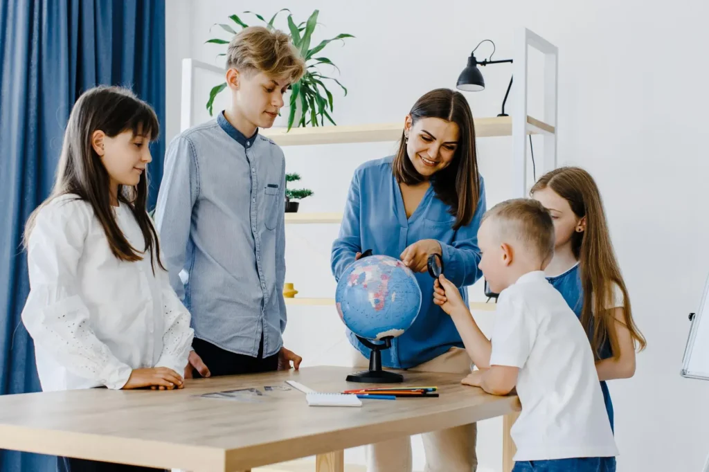 Teacher Children Class Are Looking Globe Teacher Helps Explain Lesson Children Class Desk